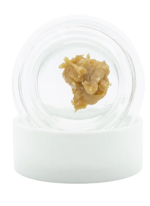 A white lid and clear jar of Hashburger Rosin concentrate